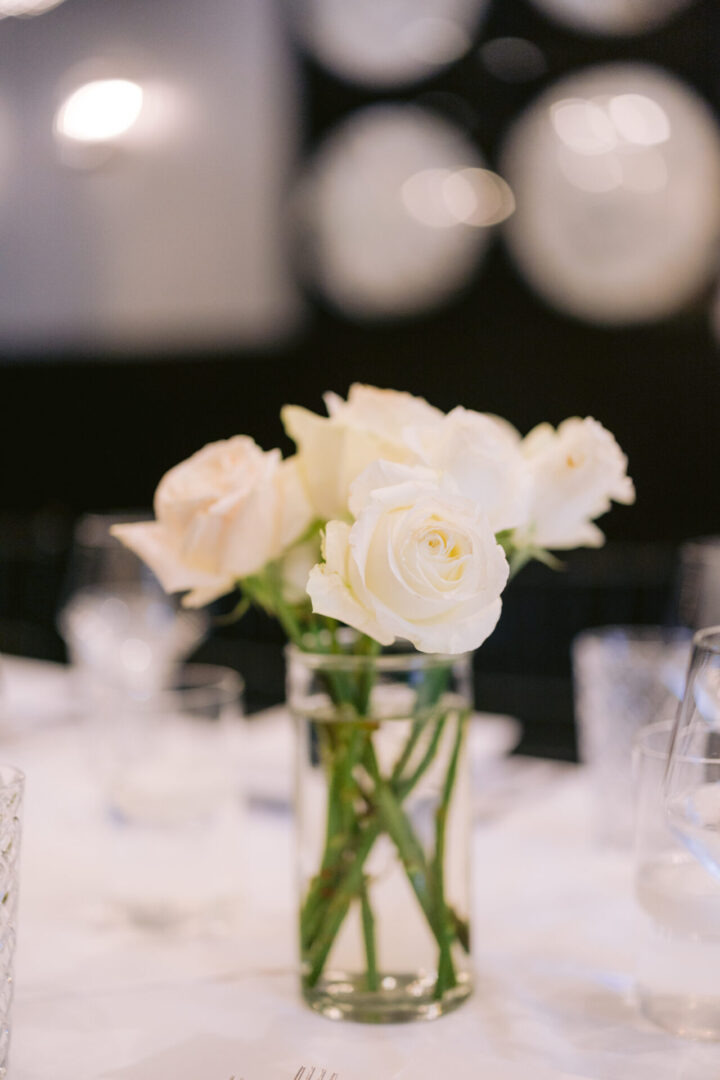 White roses in glass vase centerpiece.