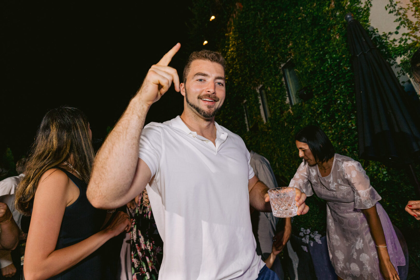 A man with a drink in his hand enjoying a reception party at Cucina Venti